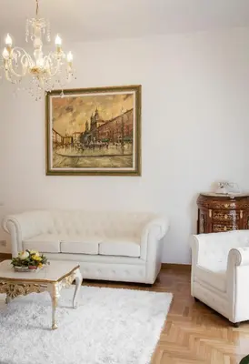 a living room with a white couch and a chandelier at Suite Sarandrea in Rome