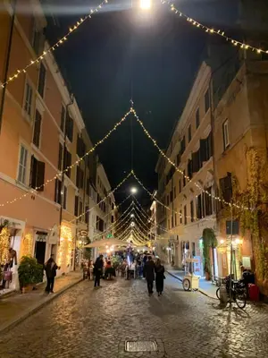a group of people walking down a street with christmas lights at Suite Sarandrea in Rome
