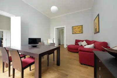 a living room with a table and a red couch at 4BNB - Spacious Belli Apartment in Rome
