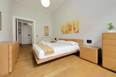 a bedroom with a large white bed and wooden furniture at 4BNB - Spacious Belli Apartment in Rome