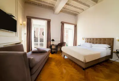 a bedroom with a bed and a couch at Splendor Suite Rome - Suites & Apartments in Rome