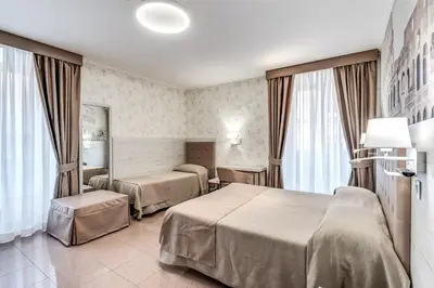 a hotel room with two beds and a mirror at Hotel Milo in Rome