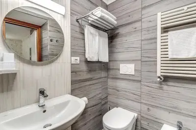 a bathroom with a sink and a toilet and a mirror at Hotel Milo in Rome
