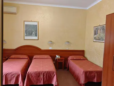 a room with two beds with red sheets at Hotel Milo in Rome