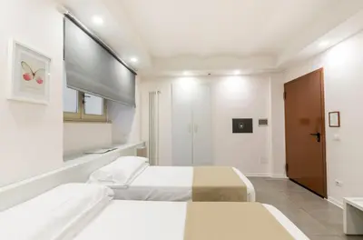 a hotel room with two beds and a bathroom at Hotel Tempio Di Pallade in Rome