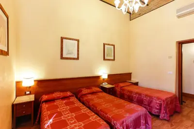 a hotel room with two beds and a chandelier at Hotel Tempio Di Pallade in Rome