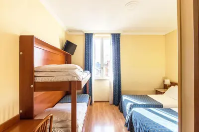 a small room with two bunk beds and a window at Hotel Tempio Di Pallade in Rome