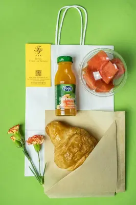 a lunch box with a bottle of orange juice and a pastry at Hotel Tempio Di Pallade in Rome