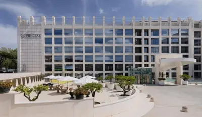 a large white building with trees in front of it at Precise House Mantegna Roma in Rome