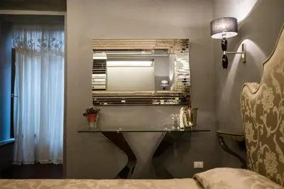 a bedroom with a glass table and a mirror at Il Covo B&B in Rome