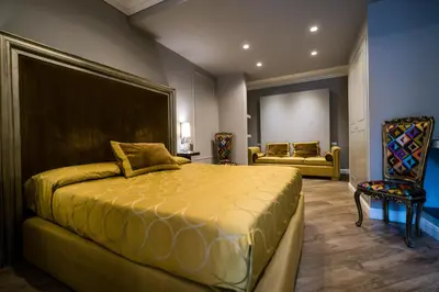 a bedroom with a large bed and a chair at Il Covo B&B in Rome