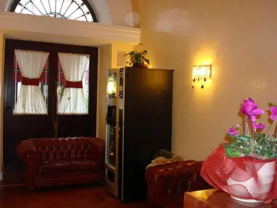 a living room with a black refrigerator and two couches at Hotel Dina in Rome