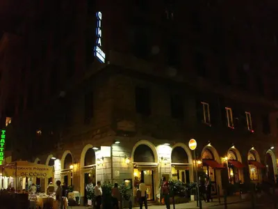 a large building with people standing outside of it at night at Hotel Dina in Rome