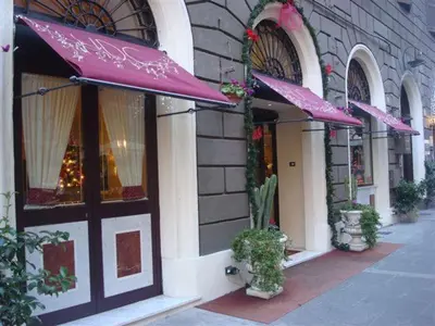 a store with purple umbrellas outside of a building at Hotel Dina in Rome