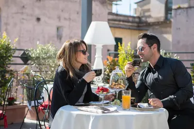 a man and woman sitting at a table drinking wine at Dharma Boutique Hotel & SPA in Rome