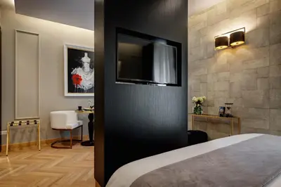 a hotel room with a bed and a flat screen tv at Dharma Boutique Hotel & SPA in Rome