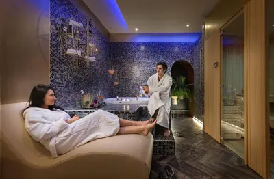 a man standing in a bathroom with a woman sitting on a couch at Dharma Boutique Hotel & SPA in Rome