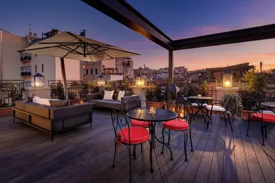a patio with tables and chairs on a roof at Dharma Boutique Hotel & SPA in Rome