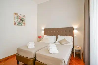 a bedroom with two beds with white sheets at Hotel St. Moritz in Rome