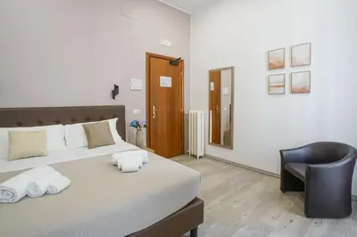 a bedroom with a bed and a black chair at Hotel St. Moritz in Rome
