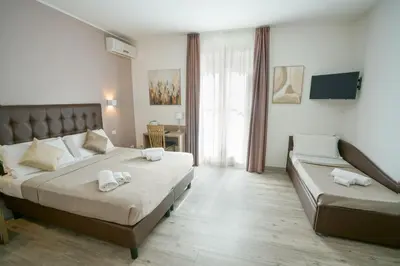 a bedroom with two beds and a couch in it at Hotel St. Moritz in Rome