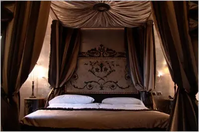 a bedroom with a canopy bed with white pillows at San Anselmo in Rome