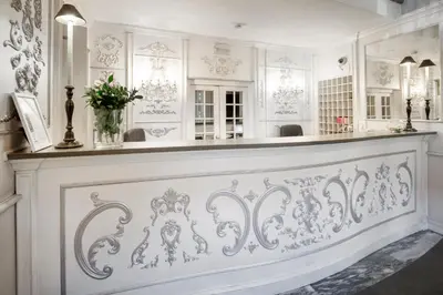 a white room with a counter with a vase of flowers at San Anselmo in Rome