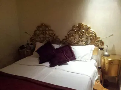 a bedroom with a white bed with a gold headboard at San Anselmo in Rome