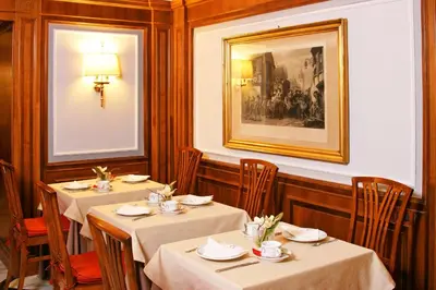 a dining room with two tables and a picture on the wall at Hotel Arcangelo in Rome