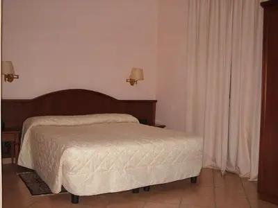 a bedroom with a bed with a wooden headboard at Hotel San Marco in Rome
