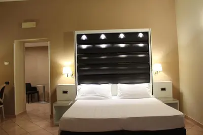 a bed with a black headboard with lights above it at Hotel San Marco in Rome