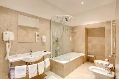 a bathroom with a sink and a tub and a toilet at Hotel San Marco in Rome