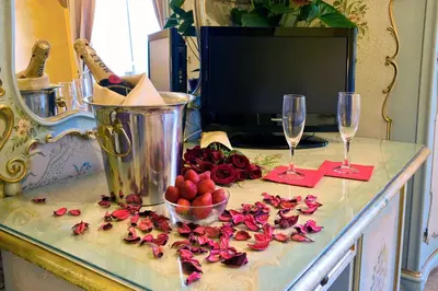a counter with two wine glasses and roses on it at Hotel Villa San Lorenzo Maria in Rome