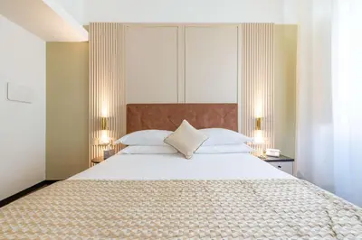 a bedroom with a large white bed with two lamps at Best Western Hotel Artdeco in Rome