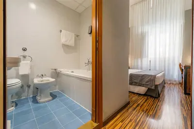a bathroom with a toilet and a tub and a sink at Best Western Hotel Artdeco in Rome
