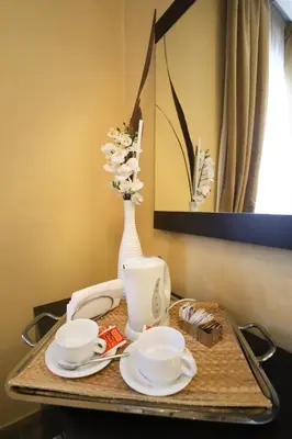 a tray with two cups and a vase with flowers at Hotel Latinum in Rome