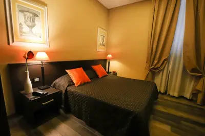 a bedroom with a bed with orange pillows on it at Hotel Latinum in Rome