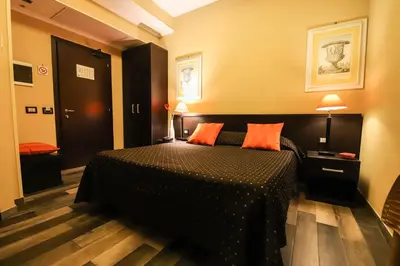 a bedroom with a bed and two orange pillows at Hotel Latinum in Rome