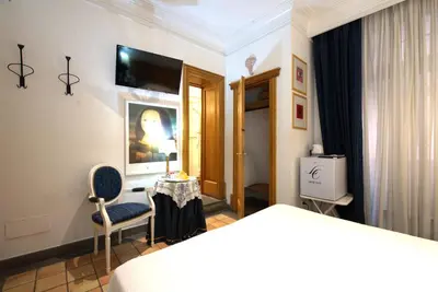 a hotel room with a bed and a chair and a table at Hotel Locanda Cairoli in Rome