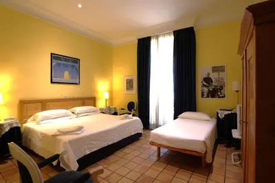 a hotel room with two beds and a window at Hotel Locanda Cairoli in Rome
