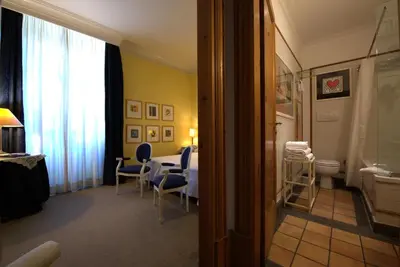 a room with a table and chairs and a bathroom at Hotel Locanda Cairoli in Rome