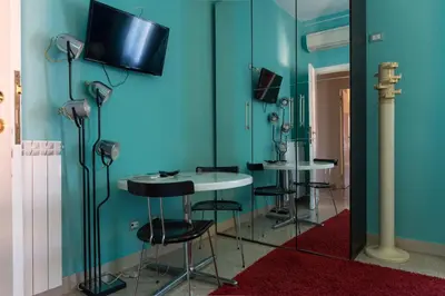 a room with two tables and a tv on the wall at B&B Anni 50 in Rome