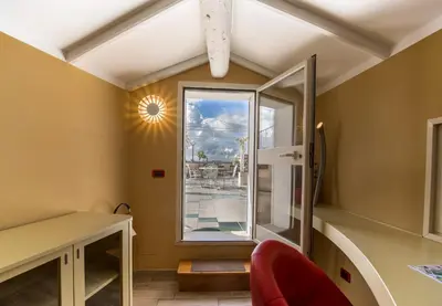 a room with a window and a red chair at Hotel Fellini a Fontana di Trevi in Rome