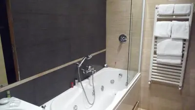 a bathroom with a tub and a shower with towels at Suite Beccaria A Piazza Del Popolo in Rome