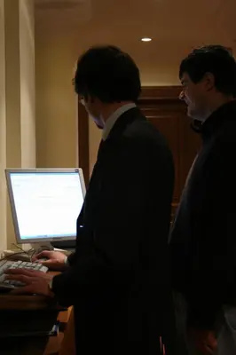 two men standing in front of a laptop computer at Suite Beccaria A Piazza Del Popolo in Rome