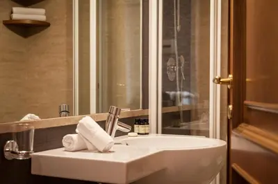 a bathroom with a white sink and a mirror at Suite Beccaria A Piazza Del Popolo in Rome