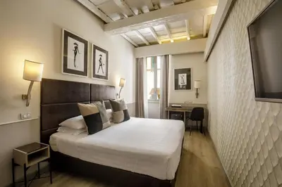 a hotel room with a bed and a television at Condotti Palace in Rome
