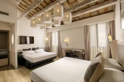 a hotel room with two beds and a tv at Condotti Palace in Rome