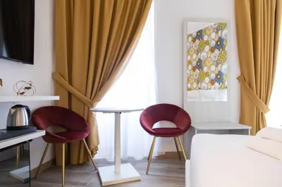 a bedroom with two chairs and a table and a bed at Hotel Cinquantatre in Rome