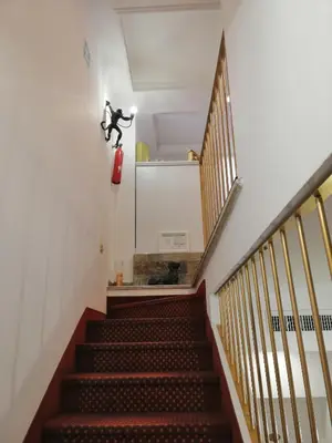 a staircase with a person on a fire extinguisher on the wall at Hotel Cinquantatre in Rome